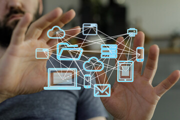 A man interacts with a visual representation of a digital network, showcasing cloud storage, file...