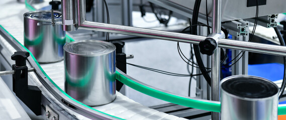 Canned food products on conveyor belt in distribution warehouse. parcels transportation system concept