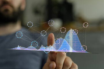 Interactive data visualization.  Person analyzes graphs, charts, and data trends using finger.