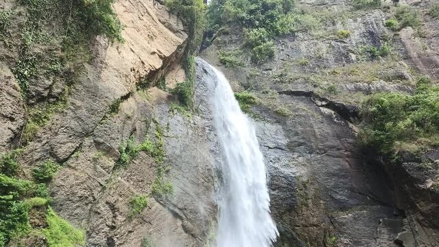 footage of a waterfall in the middle of the forest with a very beautiful cliff, the name is Sarasah Barasok waterfall in West Sumatra