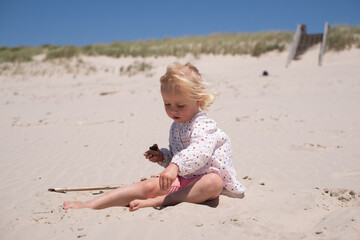 Little Girl Playing Alone in the Sand on the Beach