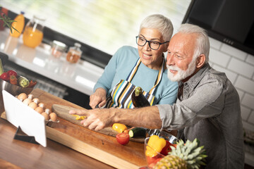 Home, cooking and senior couple with a tablet
