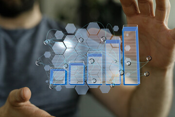 Stock photo of hands interacting with a digital bar graph showing business growth and data analysis.