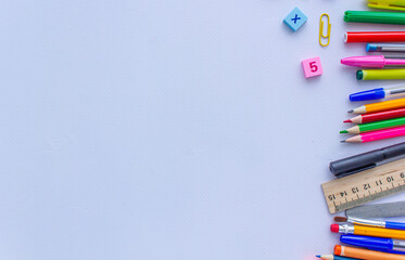 Red, pink, yellow paper clips and rubber bands on white background, school photo background