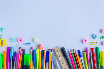 Fototapeta premium Stationery for school, photo background, multi-colored pencils, paper clips, scissors, pens, markers, red, yellow, green colors