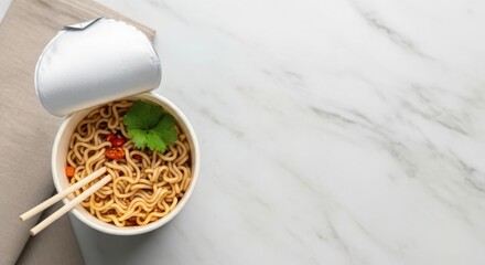 A takeout container filled with noodles, garnished with cilantro and red chili. Two chopsticks rest beside the container on a marble surface.