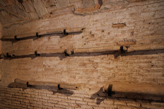OSTIA ANTICA, ITALY, JULY 24, 2022: Ancient Roman lead pipes on a brick wall in Ostia Antica, showcasing historical plumbing techniques