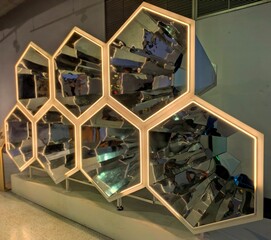 Hexagonal mirrored wall with illuminated edges.