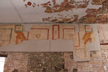 OSTIA ANTICA, ITALY, JULY 24, 2022: Ancient fresco fragments on a wall with colorful geometric patterns and symbols, partially restored
