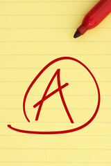 Getting a great grade with A mark with a red marker on ruled loose leaf notebook paper