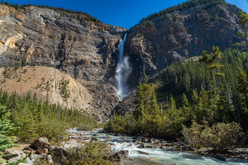 Takakkaw Falls Waterfall and Yoho River in a sunny summer day. Natural scenery landscape in Yoho National Park, Canadian Rockies, British Columbia, Canada.
