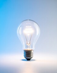 Brightly glowing traditional incandescent light bulb isolated on a soft, radiant gradient background, symbolizing brilliant ideas, innovation, and classic illumination