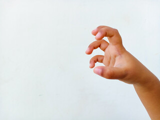 A close-up image of a child's hand making a claw-like gesture against white background.