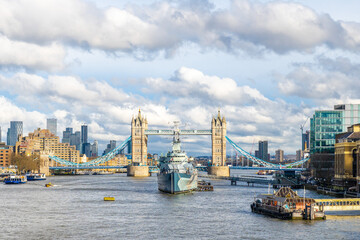 Obraz premium Hms belfast warship sailing under tower bridge in london, united kingdom