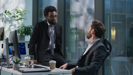 African American Caucasian men chatting talking break relax team businessmen business males looking computer monitor winning good news successful deal celebrate guys happy coworkers colleagues office