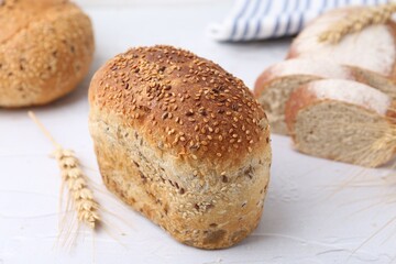 Freshly baked loaves of bread and spikes on light textured table, closeup