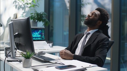 Tired African American man working web online with computer businessman male bored guy business depressed unhappy sad manager employer entrepreneur in office exhausted worker fatigue overwork indoor