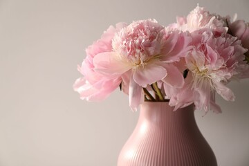 Bouquet of beautiful peonies on light grey background, closeup. Space for text