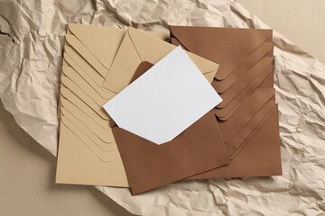 Blank invitation card, envelopes and parchment paper on carton, top view. Space for design