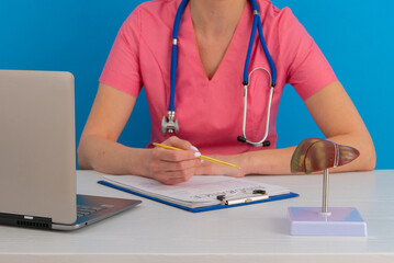 Doctor work in office with anatomical model of human liver on desk. Concept of healthy liver and donation.