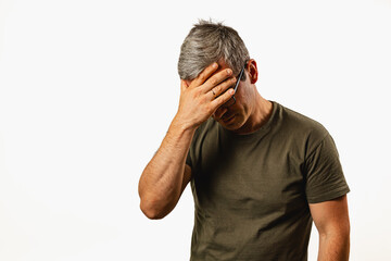 Man expressing frustration with hand on forehead indoors