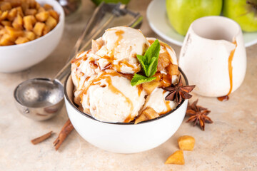 Homemade apple pie ice cream. Bowl of traditional autumn apple pie or strudel gellato, with caramelized apples, sponge cake biscuit crumble, caramel sauce, cinnamon and spices
