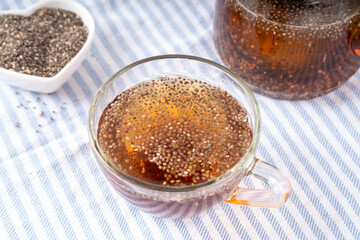 Chia seeds tea, trendy healthy chia infused drink, alternative natural energy source, diet weight-loss drink, in teapot and tea cup, copy space
