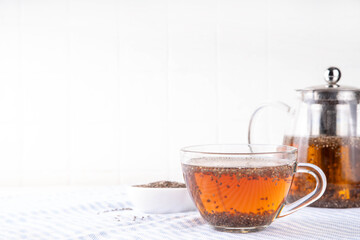 Chia seeds tea, trendy healthy chia infused drink, alternative natural energy source, diet weight-loss drink, in teapot and tea cup, copy space