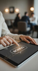 Close-up of woman's fingers interacting with tablet displaying "Bonus" in speech bubble, showcasing online reward concept in blurred cafe setting