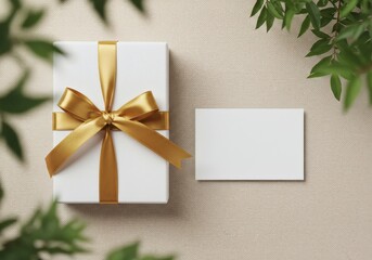 Elegant Gift Box with Golden Ribbon and Blank Card on Textured Background with Greenery