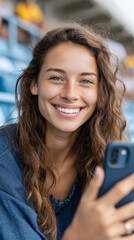 Joyful parent capturing memories in bleachers with phone at sports event