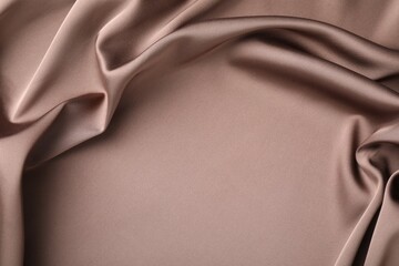 Crumpled light brown silk fabric as background, top view