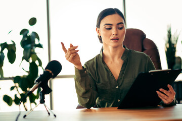Professional businesswoman in office workstation, reviewing documents, presenting ideas, wearing...