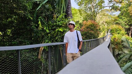 Handsome south east asian man travel alone walking calmly in the forest destination