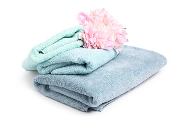 Stack of soft towels and peony flowers isolated on white
