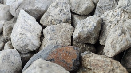 Granite stone backdrop: A detailed close-up showcases a pile of rough-hewn granite stones, displaying their textured surfaces, diverse shapes, and earthy tones.