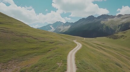 Winding dirt road through a valley nestled between mountains.