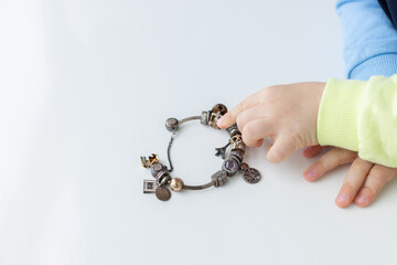 Child touching jewellery bracelet. Closeup, selective focus.