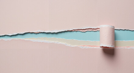 Torn paper strips in pastel colors with paint roller on tabletop  