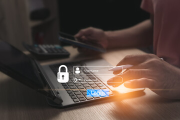 Concept of logging into online website on laptop using personal username and password to prevent fraud and for cyber security. Businessman sitting working in a room with only one illuminated spot.