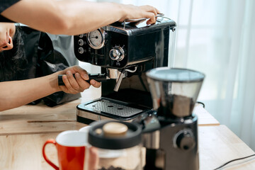 A young Asian male barista, dressed in a striped apron, skillfully creates beautiful latte art in a cozy, modern cafe, professional coffee equipment and takeaway cups.