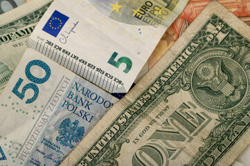 Paper banknotes of various countries of America, the European Union, and Poland close up