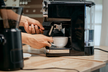 A young Asian male barista, dressed in a striped apron, skillfully creates beautiful latte art in a cozy, modern cafe, professional coffee equipment and takeaway cups.