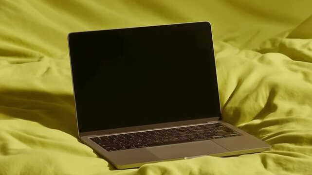 A surface of a bed with soft duvet, a mackbook pro on top of the bed, opened, the screen is facing the camera, bedsheet color is lime RGB,,, background white color