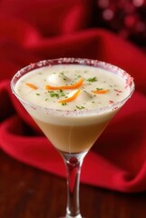 Festive Cocktail: An elegant cocktail, garnished with a festive orange peel and a sprinkle of spice, sits on a smooth red background