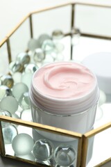 Jar of moisturizing body cream and glass tray on white table, closeup