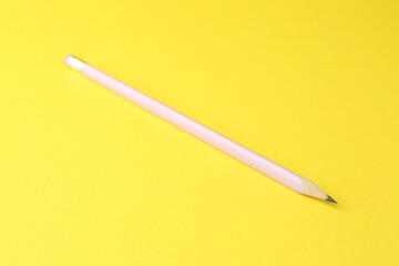 One graphite pencil on yellow background, closeup