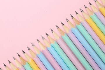 Many graphite pencils on pink background, flat lay. Space for text