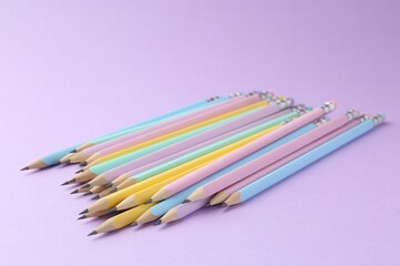 Many graphite pencils on violet background, closeup