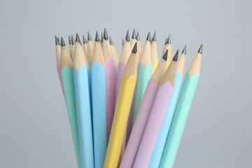 Many graphite pencils on light grey background, closeup